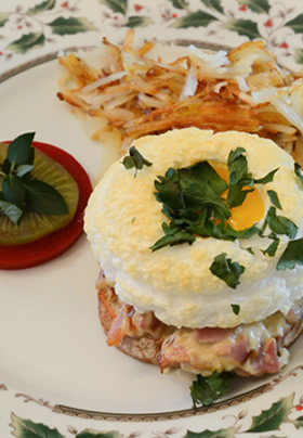 Cream plate with Kiwi, Tomato, hashbrowns and eggs on ham, holly tablecloth.